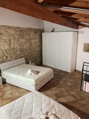 a bedroom with two beds and a brick wall at Casa Vacanza 
