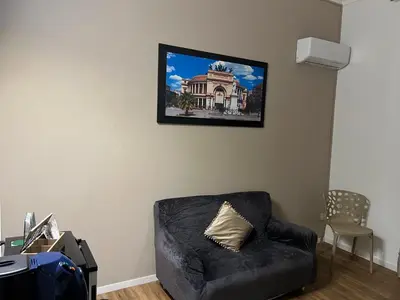 a living room with a black chair and a picture on the wall at Le suite di Alba in Palermo