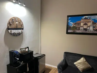 a living room with a couch and a clock on the wall at Le suite di Alba in Palermo