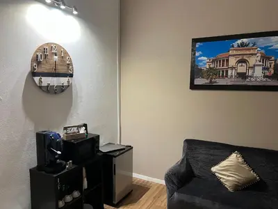 a living room with a couch and a clock on the wall at Le suite di Alba in Palermo