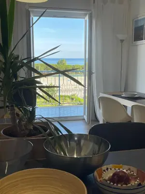 a room with a table with a view of the ocean at la vue sur la mer in Capaci