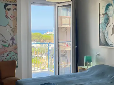 a bedroom with a view of the ocean from a balcony at la vue sur la mer in Capaci
