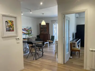 a dining room and living room with a table and chairs at la vue sur la mer in Capaci