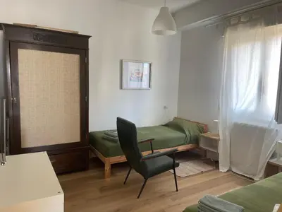 a room with a green bed and a chair at la vue sur la mer in Capaci