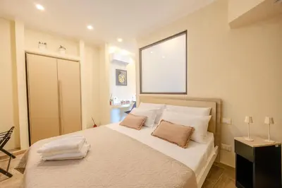 a bedroom with a bed with white sheets and a window at Damas Home in Palermo