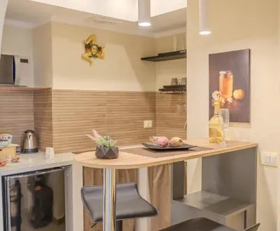 a kitchen and living room with a counter and chairs at Damas Home in Palermo