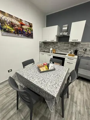 a kitchen with a table and chairs in a room at Blue Wave Apartment in Palermo
