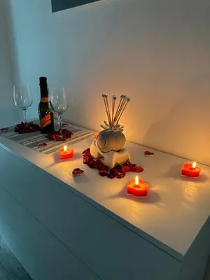 a table with candles and wine glasses and a plant on it at Blue Wave Apartment in Palermo