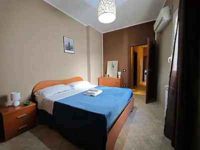 a bedroom with a bed with a blue blanket at Casa Pitrè in Palermo