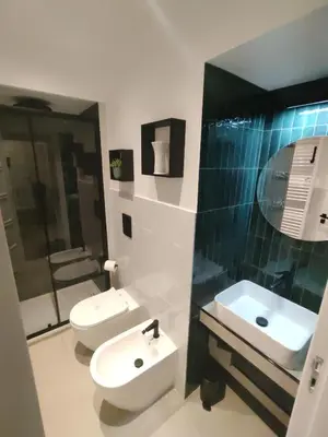 a bathroom with two toilets and a sink and a mirror at Quintadecima Rooms in Palermo