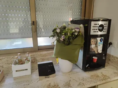 a kitchen counter with a coffee maker with a bouquet of flowers at Quintadecima Rooms in Palermo
