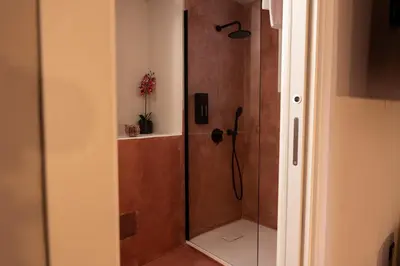 a shower with a glass door in a bathroom at Chiave di Volta luxury suite e rooms in Palermo