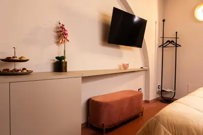 a room with a desk with a tv on the wall at Chiave di Volta luxury suite e rooms in Palermo