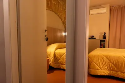 a room with two beds and a door to a bedroom at Chiave di Volta luxury suite e rooms in Palermo