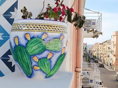 a vase with a plant on the side of a building at Casa Sciàpó in Terrasini