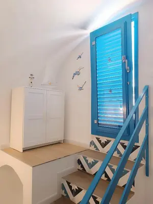 a room with a blue window and a staircase at Casa Sciàpó in Terrasini