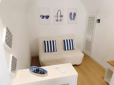 a small room with a bed with blue and white pillows at Casa Sciàpó in Terrasini