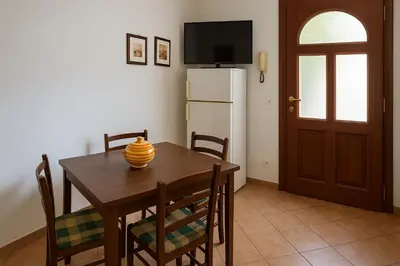 a dining room with a table with chairs and a television at SetteDì Apartment in Palermo