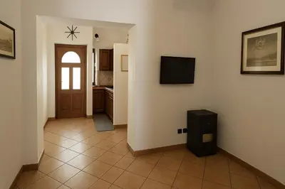 a hallway with a door and a television on a wall at SetteDì Apartment in Palermo