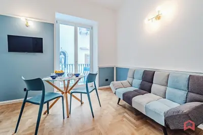a living room with a couch and a table and chairs at Nuovissimo Appartamento nel Cuore di Palermo in Palermo