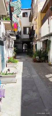 an empty alley in a city with buildings at La Riali in Palermo