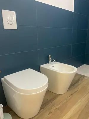 a bathroom with a white toilet and a sink at Donna Franca in Cinisi