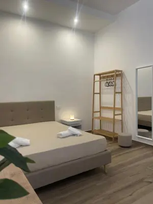 a white room with a bed and a shelf at Donna Franca in Cinisi