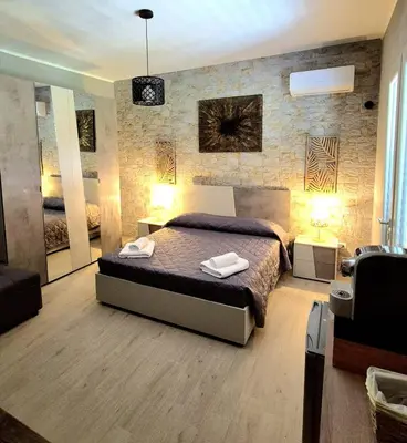 a bedroom with a bed and a brick wall at Chalet Ponte Paradiso Suite & SPA in Santa Cristina Gela