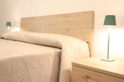 a bedroom with a bed with a wooden headboard and a lamp at Appartamenti Mari' 2 in Palermo