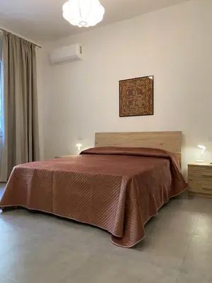 a bedroom with a bed with a brown bedspread at Appartamenti Mari' 2 in Palermo