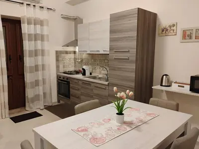 a kitchen with a table with a vase of flowers on it at Casa dalla Zia Maria in Capaci