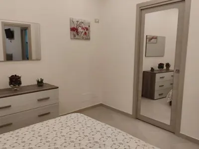 a bedroom with a mirror and a bed and a dresser at Casa dalla Zia Maria in Capaci