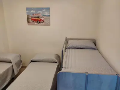 two beds in a room with a picture of a bus at Casa dalla Zia Maria in Capaci