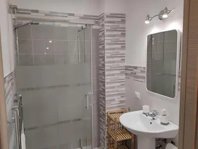 a bathroom with a sink and a shower with a mirror at Casa dalla Zia Maria in Capaci