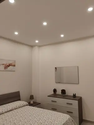 a bedroom with two beds and a mirror on the wall at Casa dalla Zia Maria in Capaci