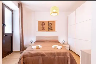 a bedroom with a large bed with two towels at La casetta di Andrea in Palermo