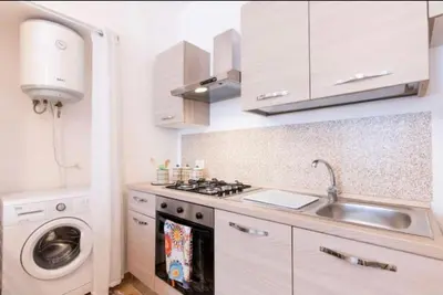 a kitchen with a sink and a washing machine at La casetta di Andrea in Palermo