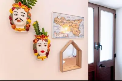 a room with two masks and a mirror on a wall at La casetta di Andrea in Palermo