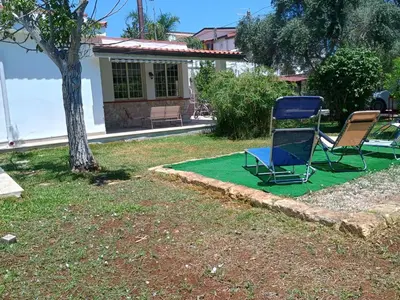 two chairs sitting on a green lawn in front of a house at Il Giardino di Lia in Palermo