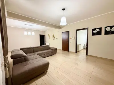 a large living room with a brown couch and wooden floors at Infinity Home in Palermo