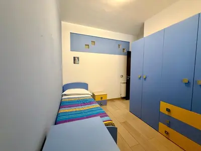 a small bedroom with two beds and blue cabinets at Infinity Home in Palermo