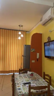 a dining room with a table and a refrigerator at Monolocale Signorile in Castellammare del Golfo