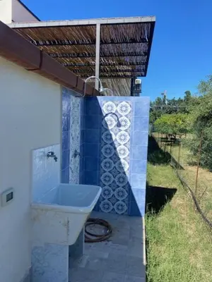 a bathroom with a toilet on the side of a house at I Carrubi in Lascari