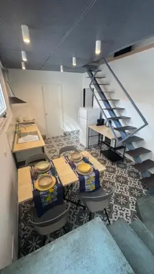 a room with a table and chairs and a staircase at Casarkeb in Terrasini