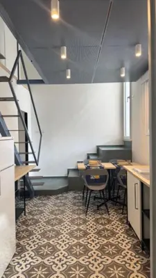 a room with tables and chairs and a staircase at Casarkeb in Terrasini