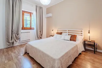 a white bedroom with a large white bed and a window at Domus Rosae in Palermo