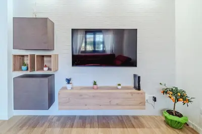a living room with a flat screen tv on a wall at Domus Rosae in Palermo