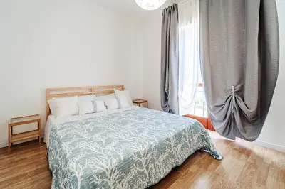 a bedroom with a bed and a large window at Domus Rosae in Palermo