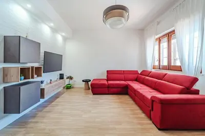 a living room with a red couch and a television at Domus Rosae in Palermo