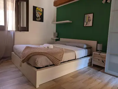 a bedroom with a bed with a green wall at A casa della Vero in Palermo